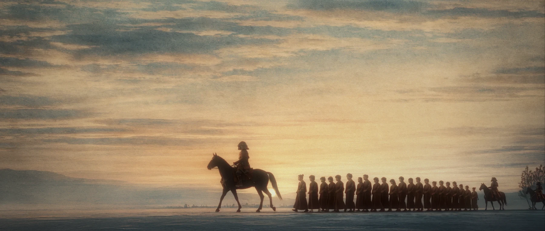 A long procession crossing a winter landscape
